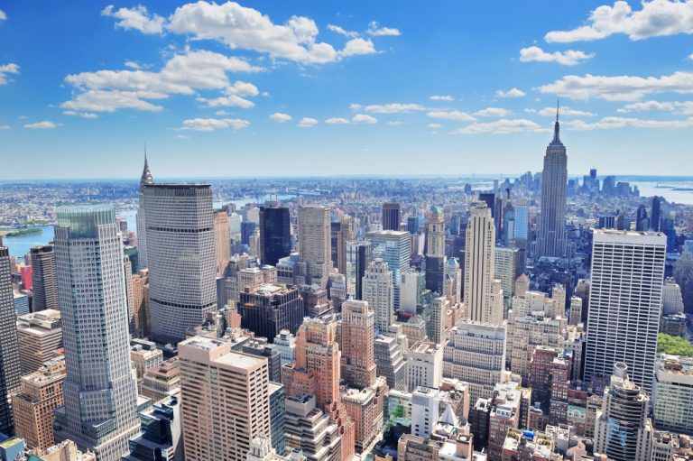 New York City Manhattan midtown aerial panorama view with skyscrapers and blue sky in the day.