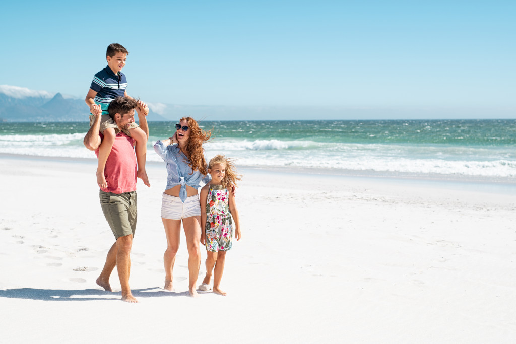 family walking by the beach during a sunny day